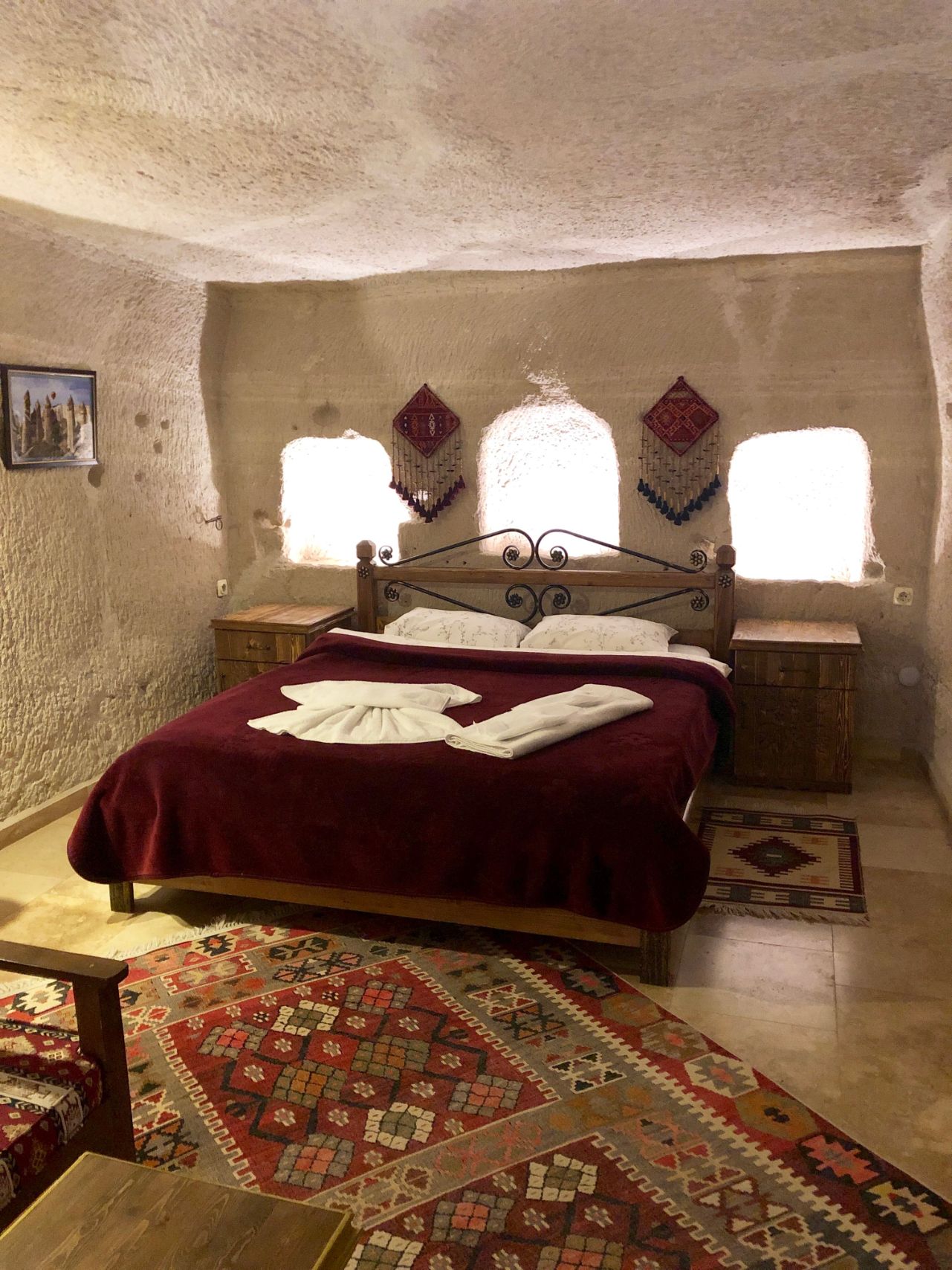 cozy cave room in Cappadocia with stone walls and a red bed