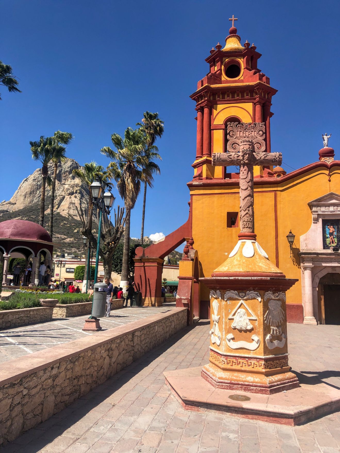 orange church with Pena de Bernal rising in the distance